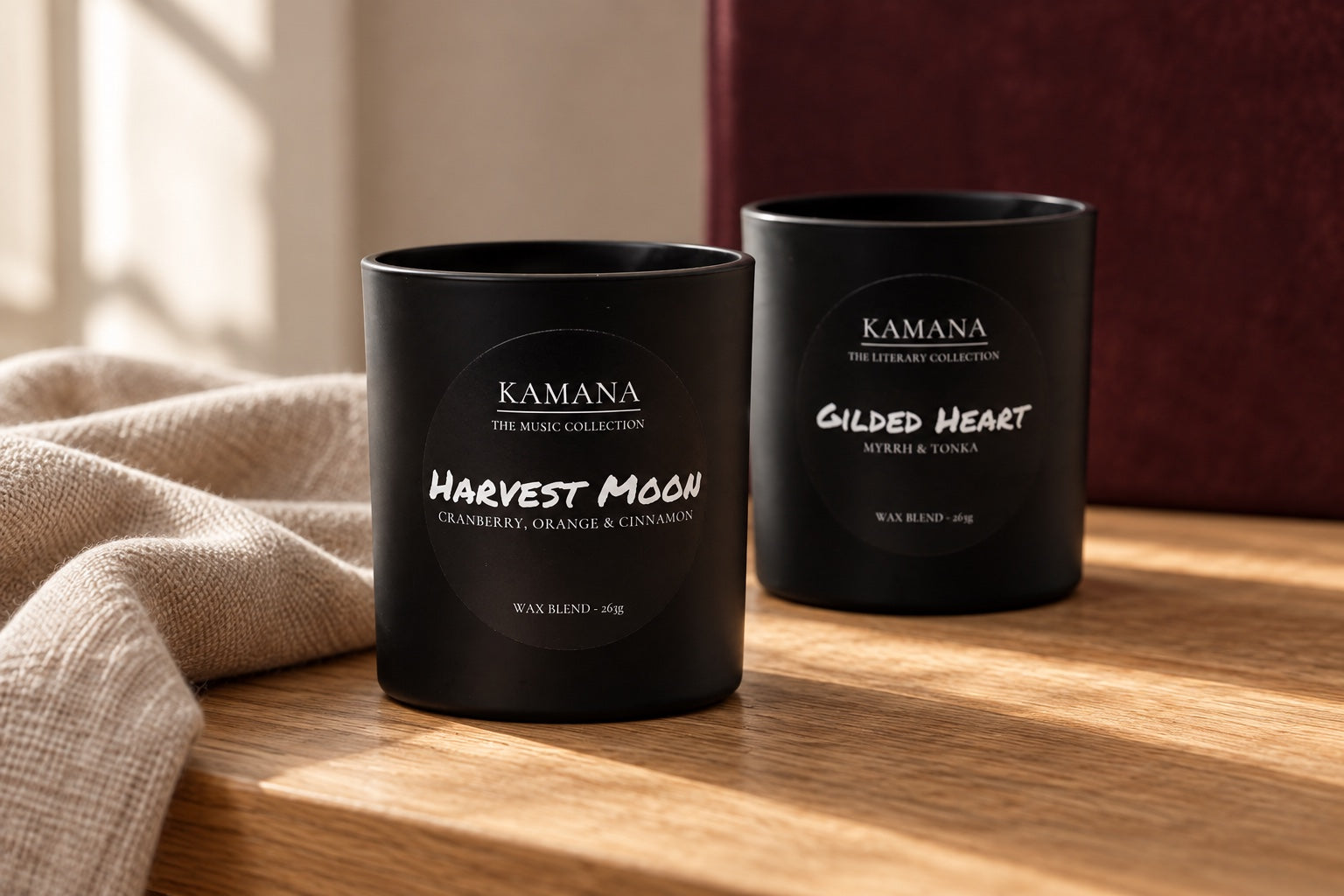 AI-styled scene of Harvest Moon and Gilded Heart candles on oak beside linen